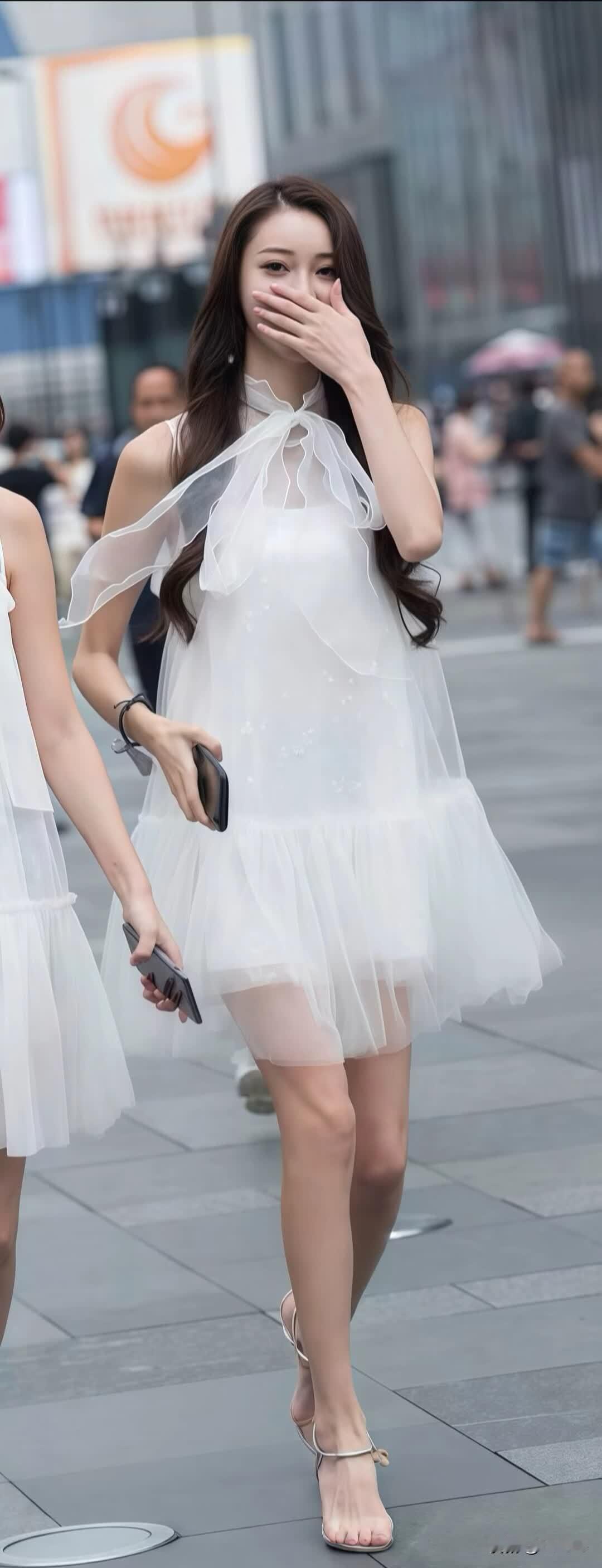 两位穿白色连衣裙的女士在街上走。