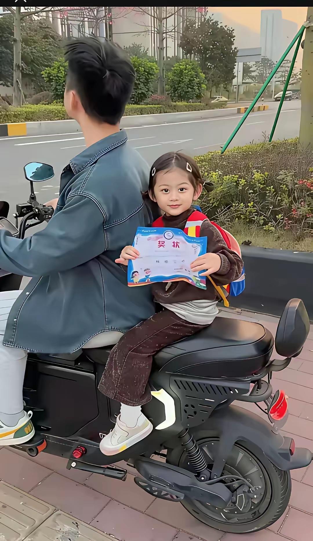 放学路上，爸爸骑电动车载着小朋友，她手里紧紧攥着新得的奖状，会扭头偷偷显摆，小下