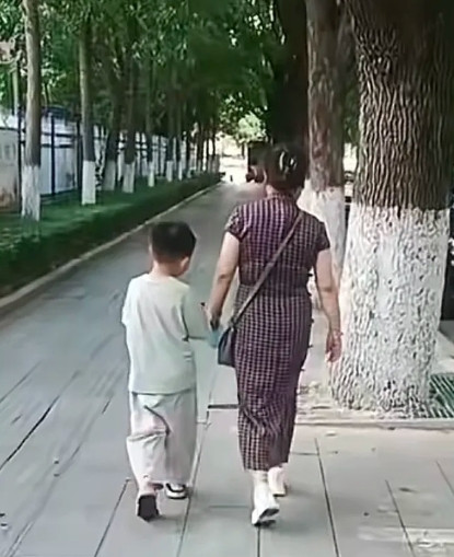 杜大娘今天走出了六亲不认的步伐！大娘穿着旗袍，斜挎小包，带着孙子言宝，雄赳