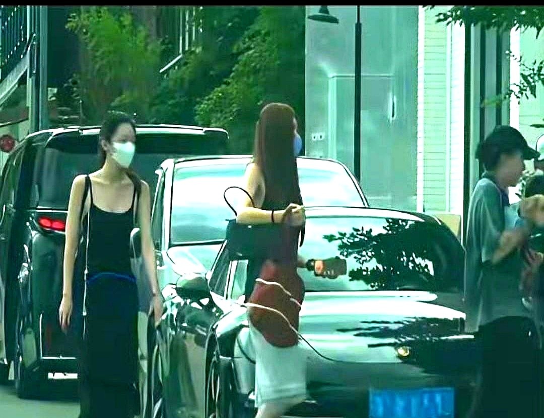 窦靖童单手托着只小狗走在最前头，身后跟着穿黑吊带的李嫣和一身黑白搭的宋妍霏。这仨人凑一块压马路，没戴
