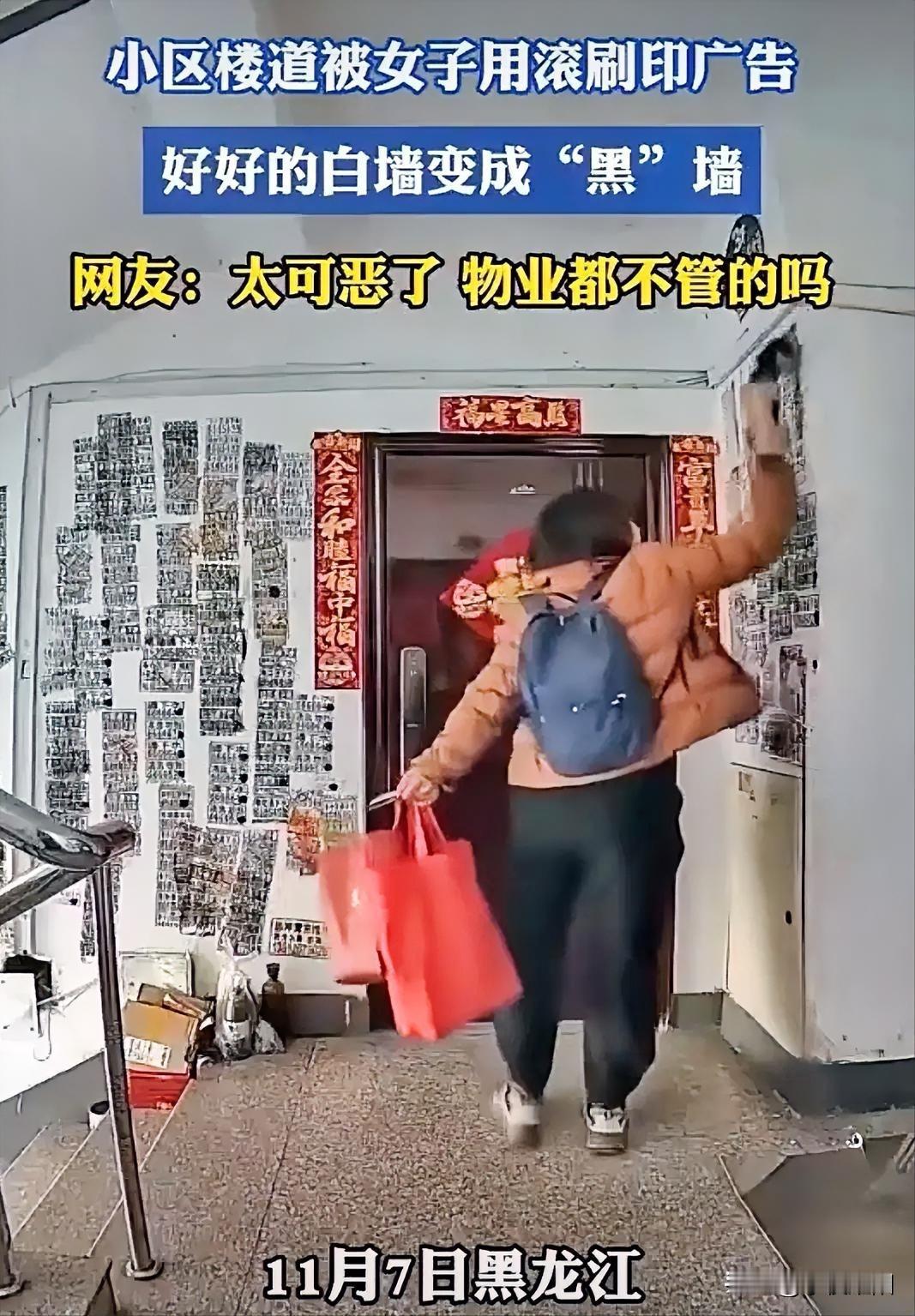 黑龙江某地一小区楼道监控拍下了一户主家门口遭一女子用滚刷在墙上刷广告的视频，顿时