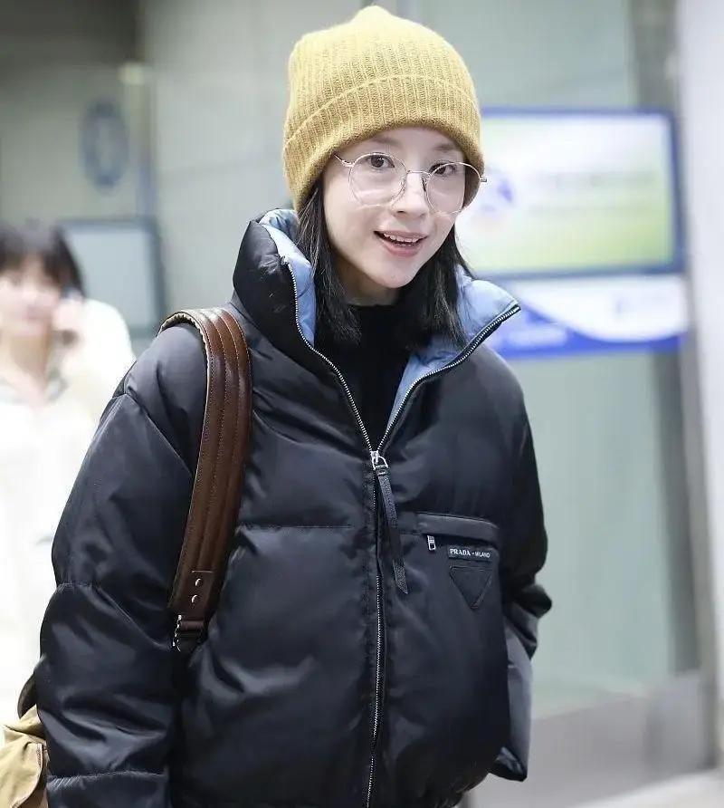 董洁去年米兰街头一件米白羽绒服配黑毛衣直筒裤，被摄影师随手一拍，直接火到国内。