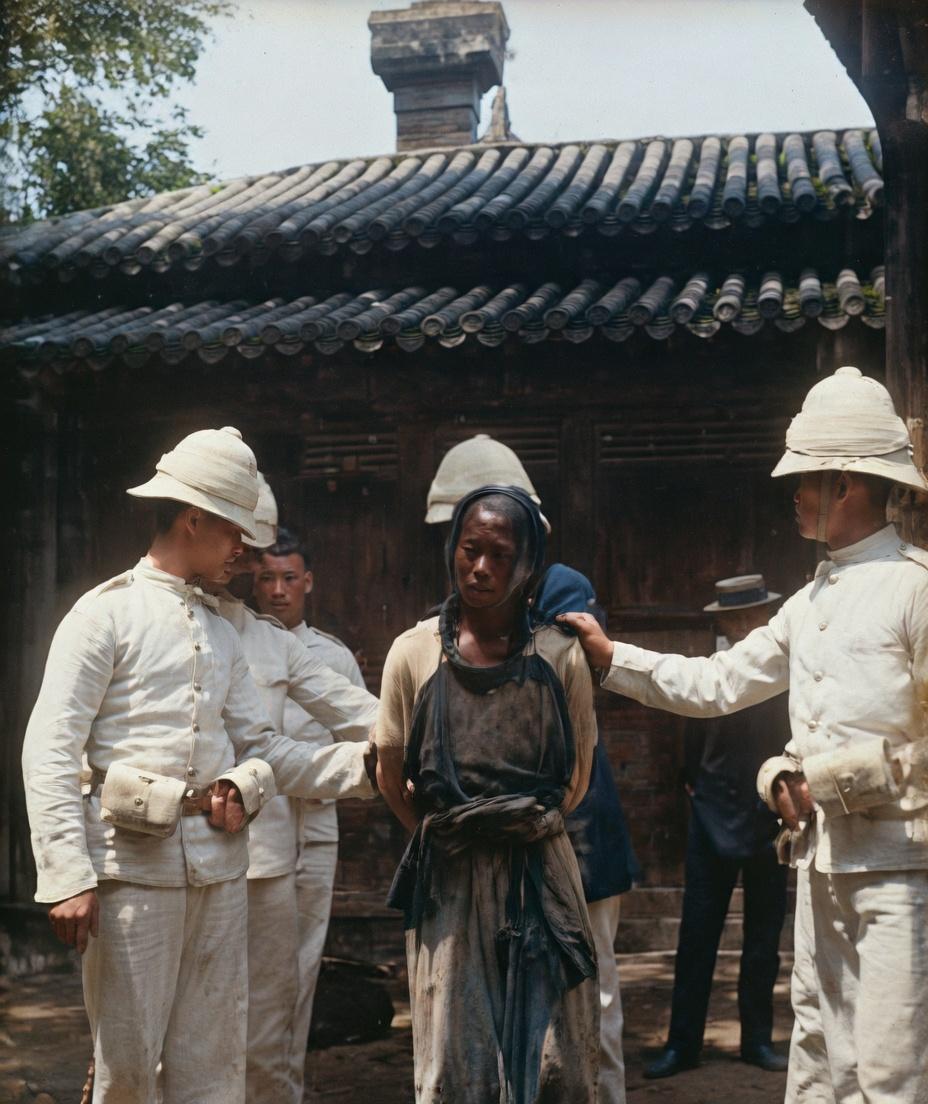 八国联军侵华期间，一名义和团成员被英军士兵抓捕的瞬间，他衣衫褴褛、头发凌乱，双手