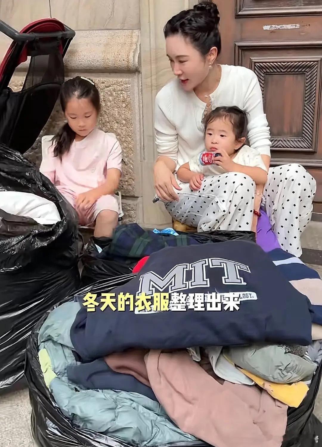 张纪中一家为山区儿童捐赠冬季衣服，杜星霖坐在别墅门口整理4个小孩不穿的小衣服，都