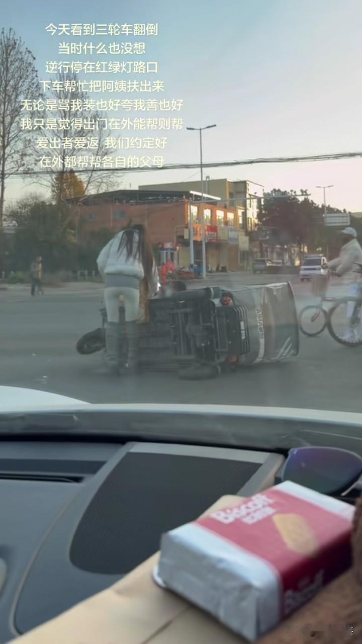 人美心善！小姐姐看到一位阿姨的三轮车翻倒了，将车子逆行停到红绿灯路口，下车和另一