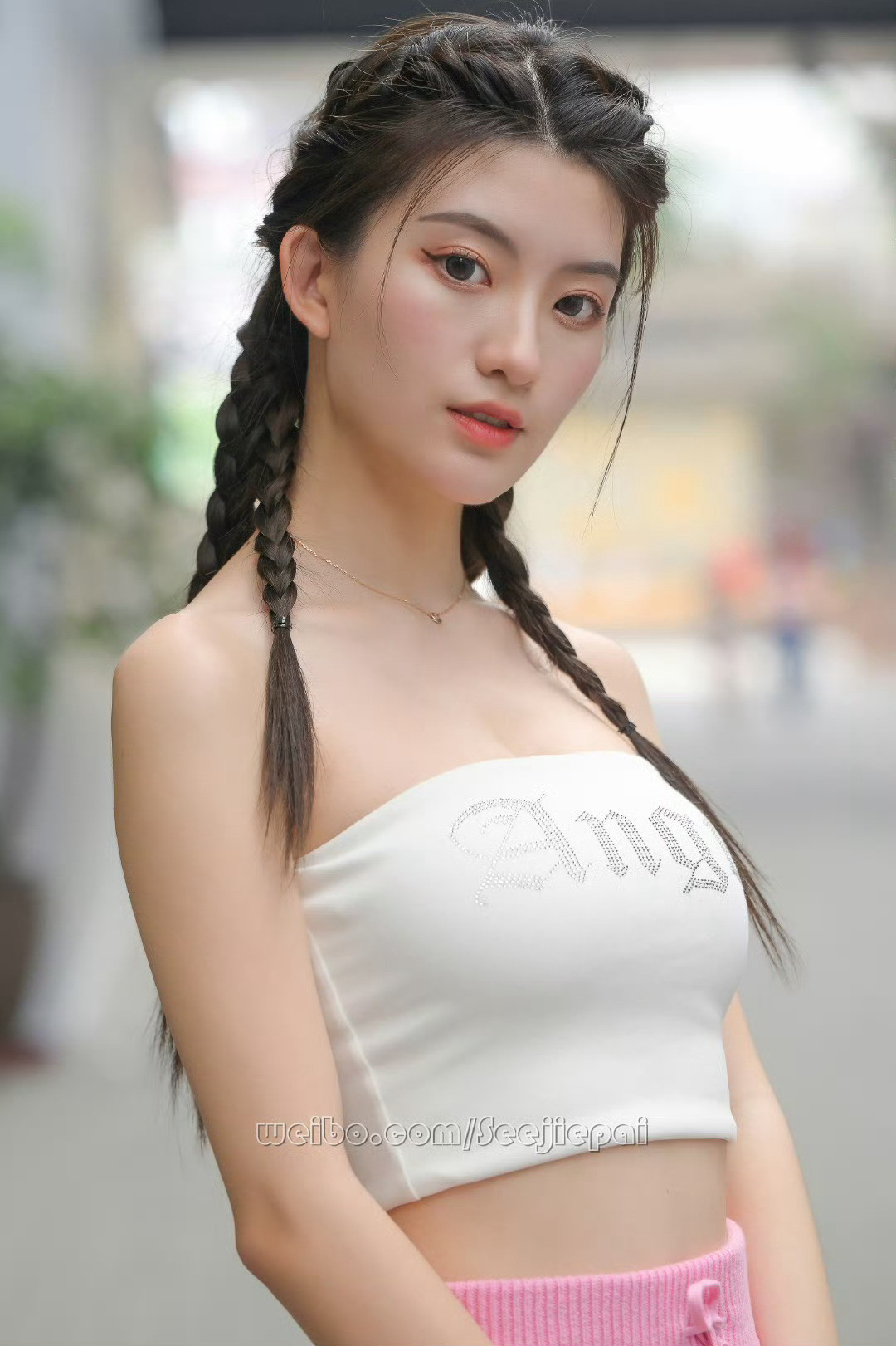 双麻花辫藏着俏皮，抹胸上衣写满辣意，粉裙把甜揉进风里。这一身，是青春在街头的即兴