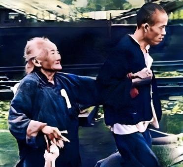 这是1937年的京沪路上一对母子拼命地逃命。儿子一只手提着全部家当，另一只紧紧握
