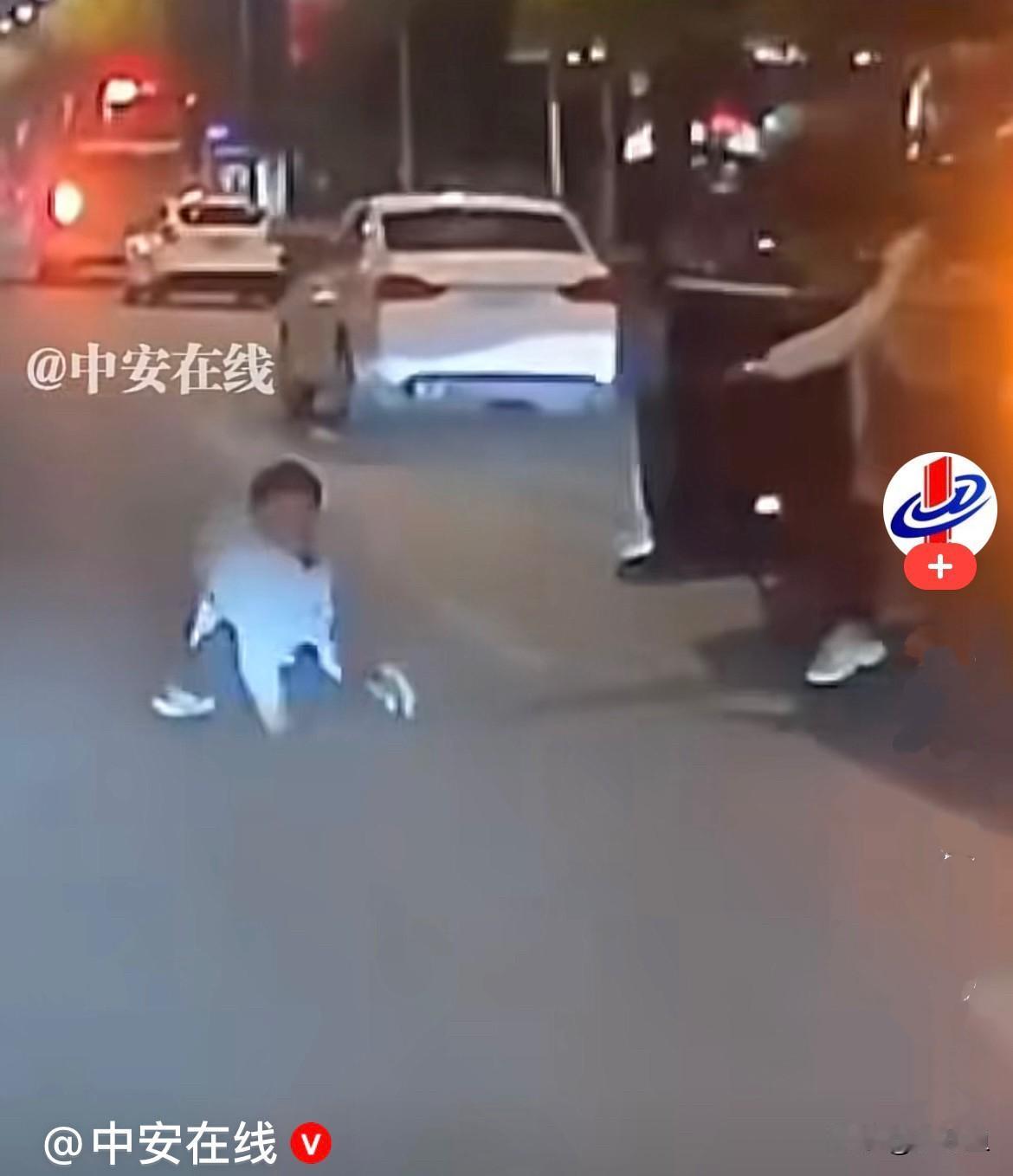 近日，江苏一马路上车辆都在正常行驶，前面一辆停着的车门打开，一女子用力把一小男孩