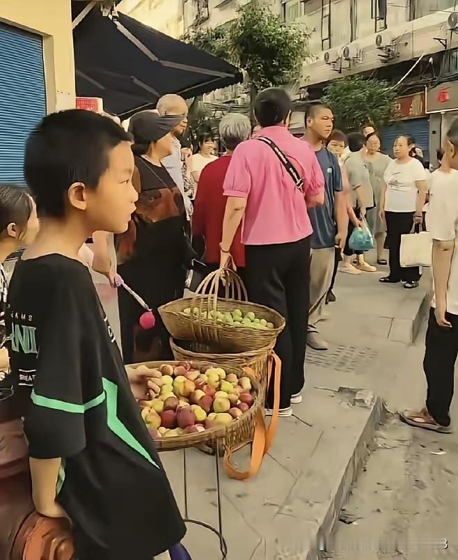 近日，四川达州市。一名10多岁的男孩在街上摆摊卖自家产出的李子。辛辛苦苦卖了