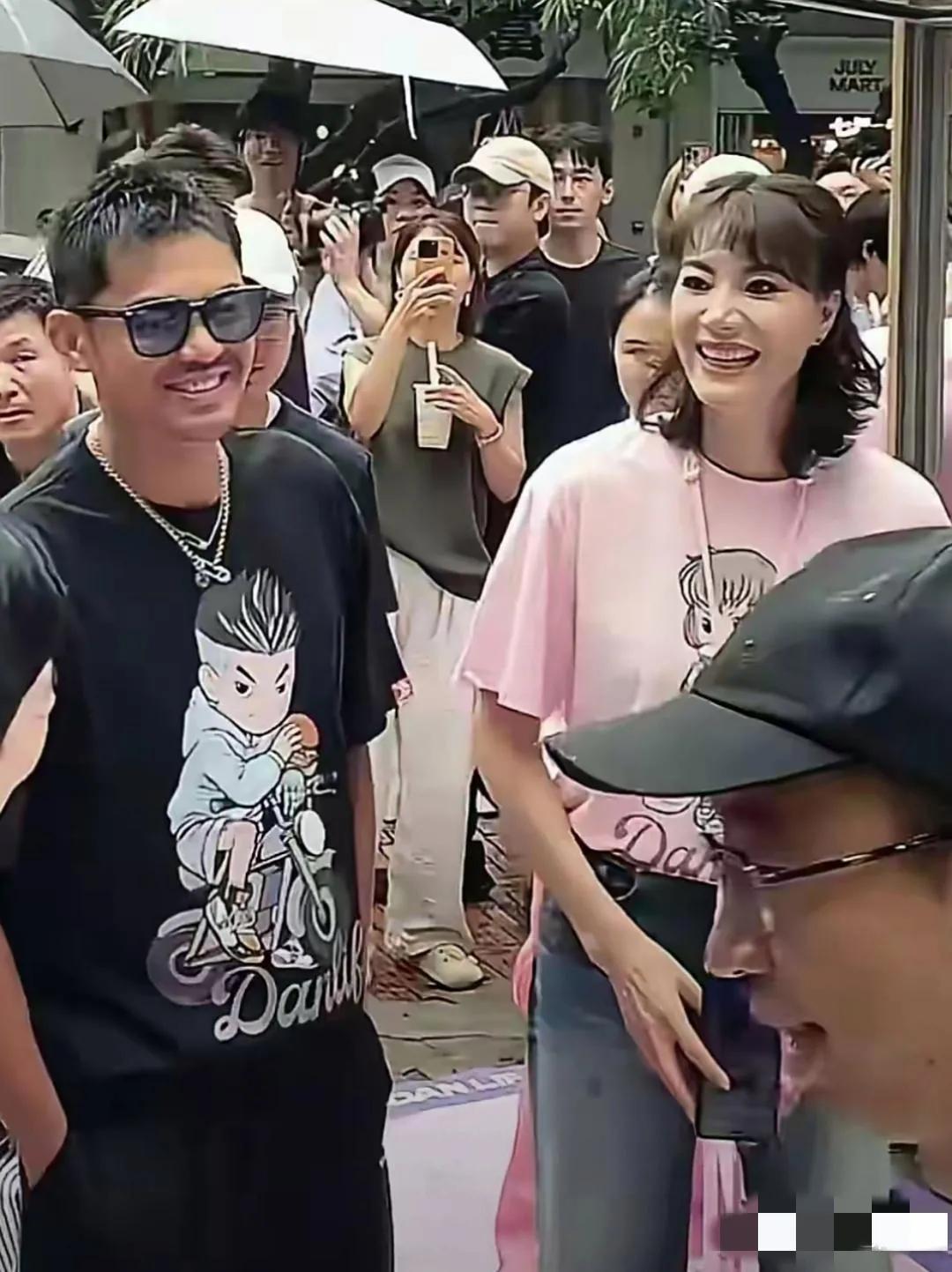 林丹与谢杏芳深圳亮相：身穿粉色T恤的谢杏芳高挑亮眼，龙眉凤目，笑容生动；身着黑色