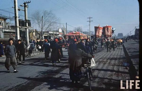 1946年，北京街头的迎亲队伍，八抬大轿是迎亲是当时传统婚礼的最高规格。民国