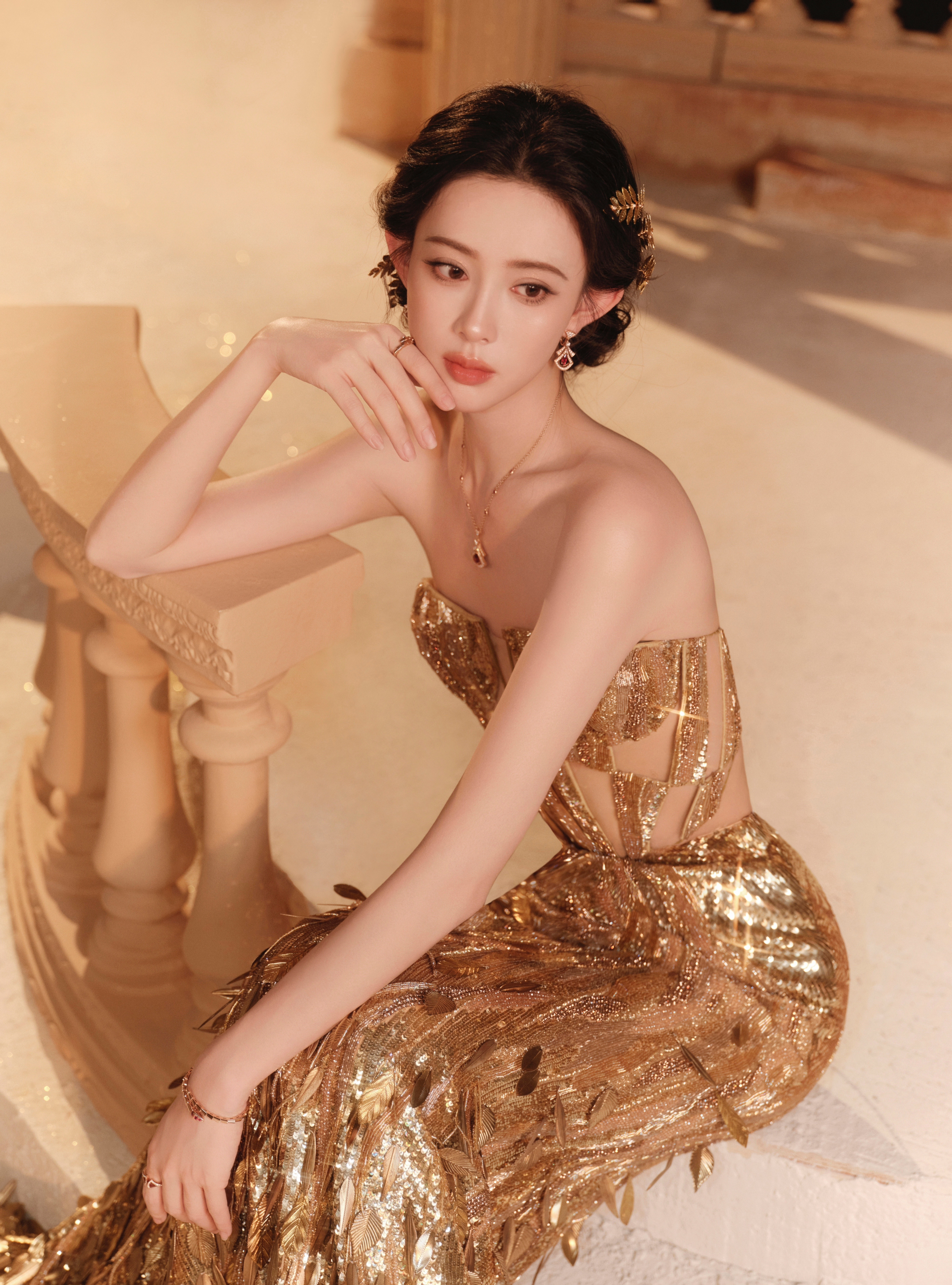 孟子义鎏金裙裾曳着落日的余温，抹胸裁出的丰盈曲线揉着华贵与媚态。孟子义鎏金女