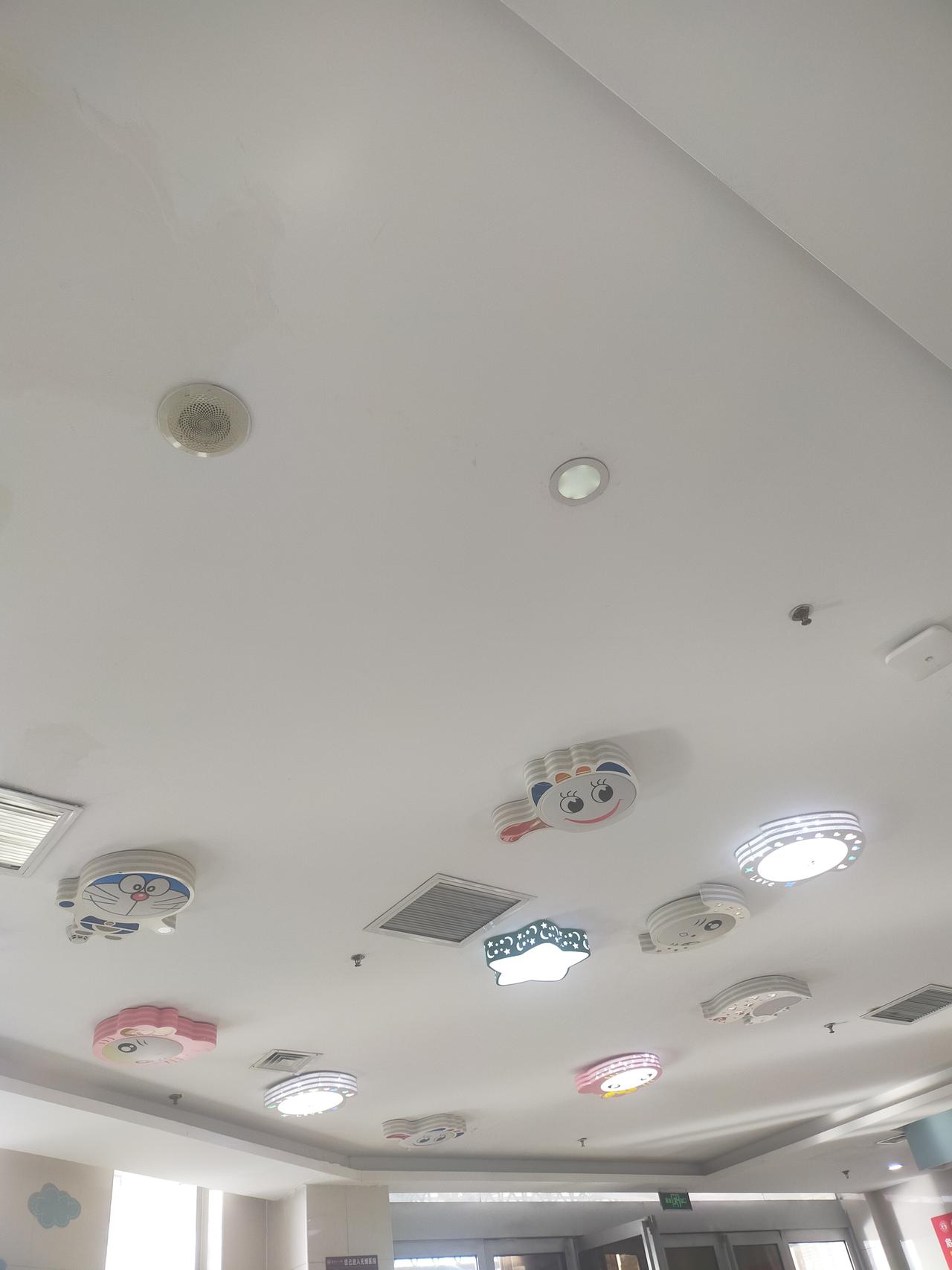 抬头瞅这天花板，也太有童趣了吧！哆啦A梦、卡通小猫的造型灯嵌在白顶里，还有粉粉嫩