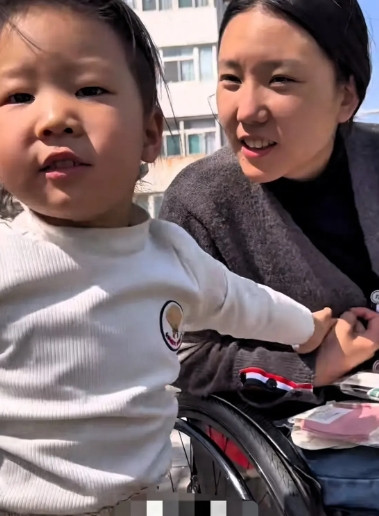 山西太原，一个坐着轮椅的妈妈带着4岁女儿去街上卖袜子，然而轮椅却卡在了台阶上，男