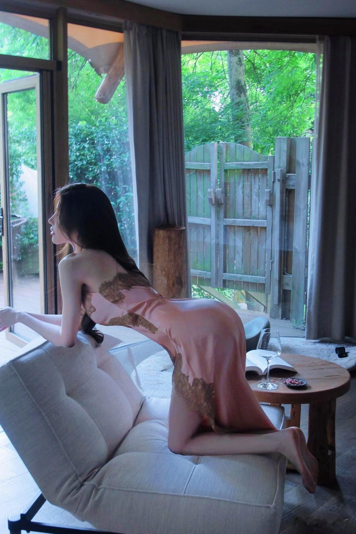 她眉眼温婉气质恬静，纤瘦身形被这袭粉色蕾丝长裙妥帖包裹。精致蕾丝面料自带肌理