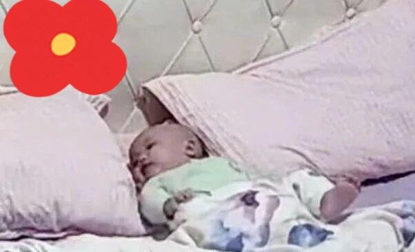 男子出门上班，把5个月大的孩子独自留在家里。没想到，孩子躺床上不哭不闹，很乖。男