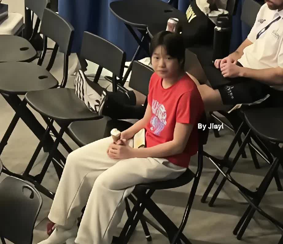 今天在活动现场撞见全红婵啦！穿红色T恤配浅色裤子，乖乖坐在椅子上，手里还举着根雪