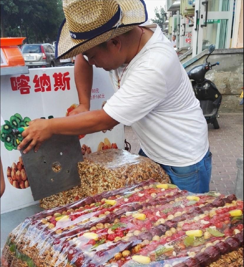 早上去菜市场买菜，回家时走到菜市场出口处，看到一对老人正在和一卖切糕的外地商贩发