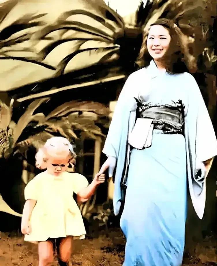 这是上世纪五十年代的日本，一位漂亮的日本女子正手牵着女儿给回美国的″丈夫″(驻日