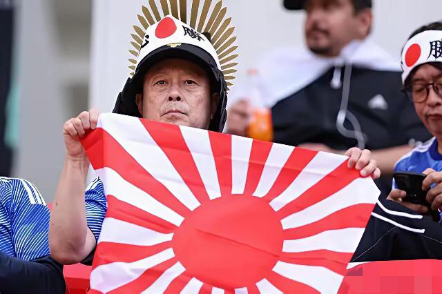 日本球迷暴露双面割裂人设！一边挥舞军国主义军旗，一边赛后弯腰捡拾垃圾！在日本对阵
