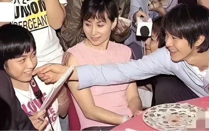 周星驰当年在宴会上隔着何超琼摸了摸年轻可爱的女娱记甘比的脸，当时的女孩还很清涩害