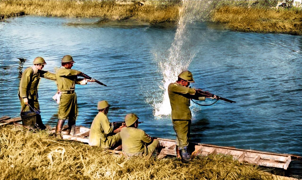1942年，5个日军在河边在一条破木船上，疯狂地朝水里射击。其中一人还使用了机枪