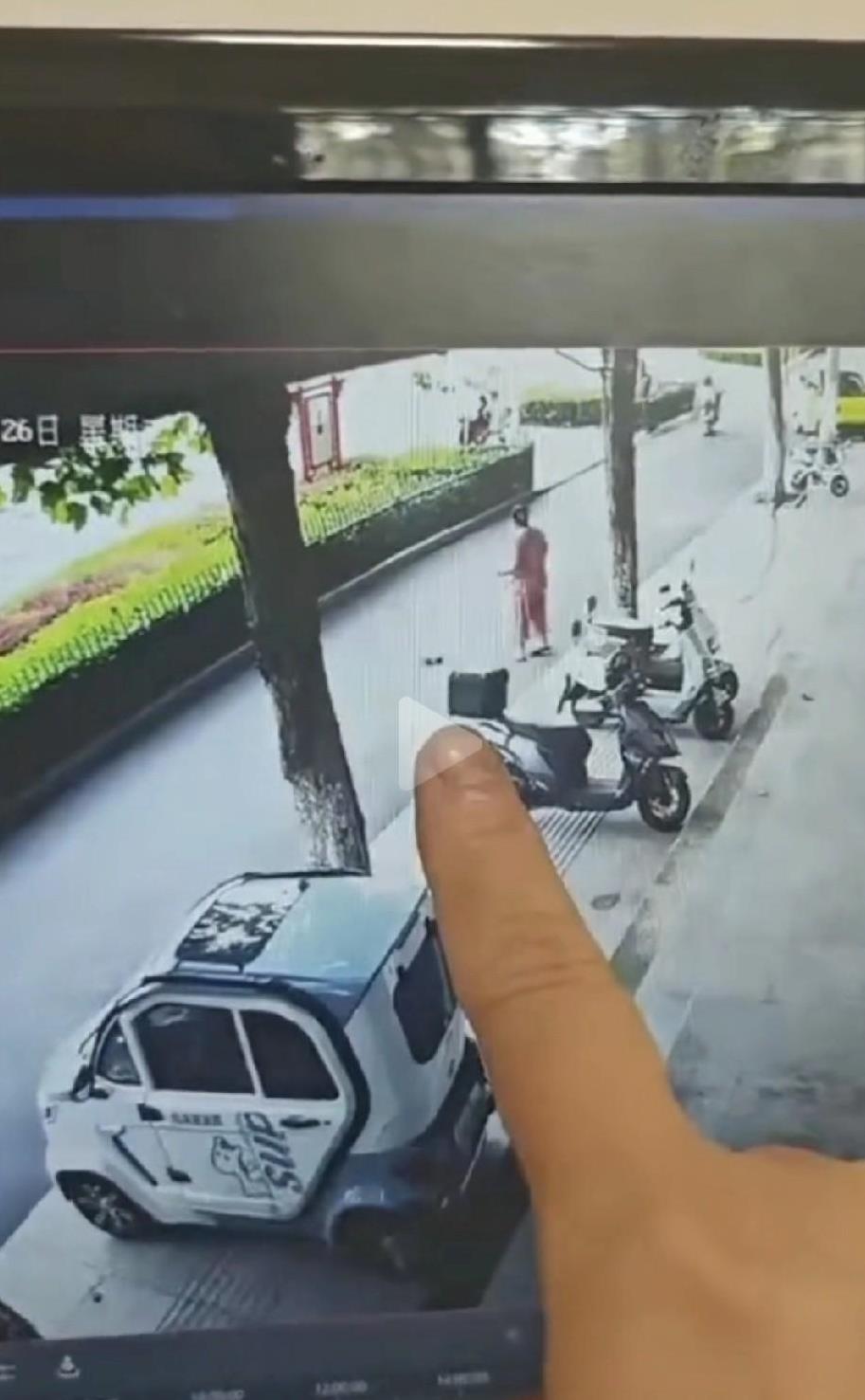 监控视频显示，一位老太太连续多日将砖头踢到马路中间。8月26日5点左右，老太太在
