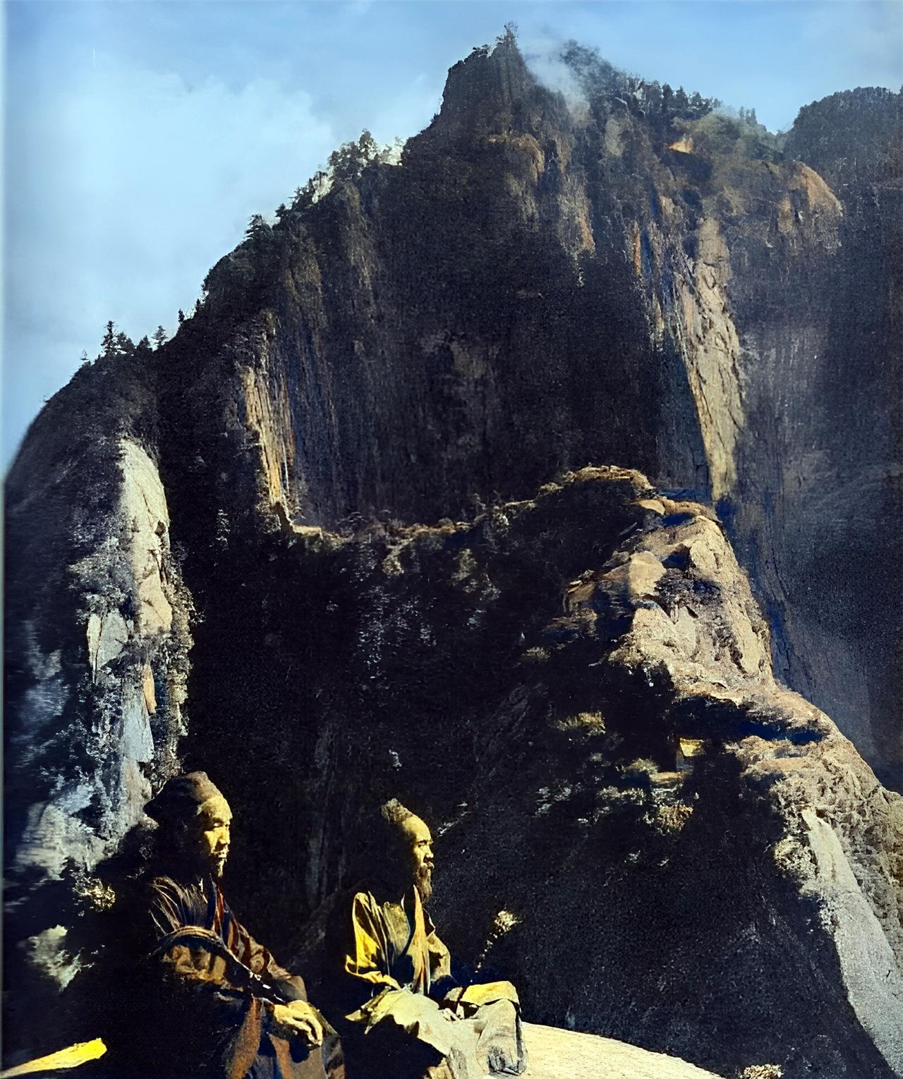 这是1935年，华山两位老道手持拂尘坐在群峰之间。两位老道好似从天而降的神仙一般