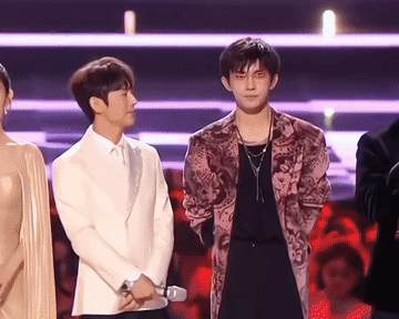 何炅看着易烊千玺的眼神太好哭了，有赞赏有欣慰更有宠溺，何老师先是悄悄的自己打量身