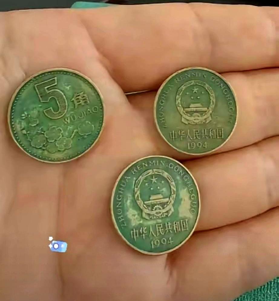 你见过绿得能当翡翠的硬币吗？前两天一个大爷来店里买烟，掏出来三枚五角硬币，那颜