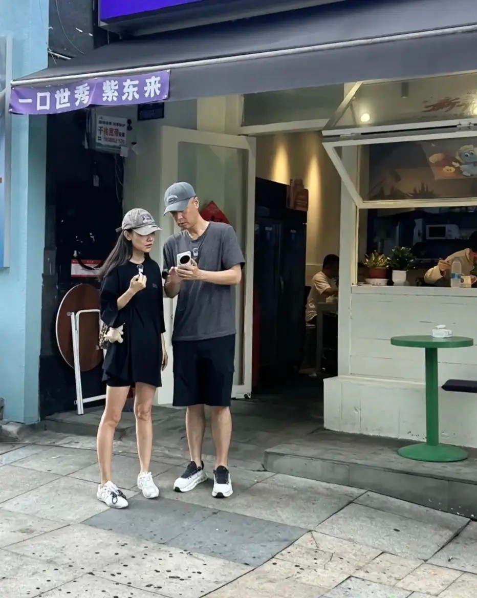47岁任重和老婆孙骁骁在重庆街边被偶遇，两人刚从一家餐馆出来，站在店门口看手机，
