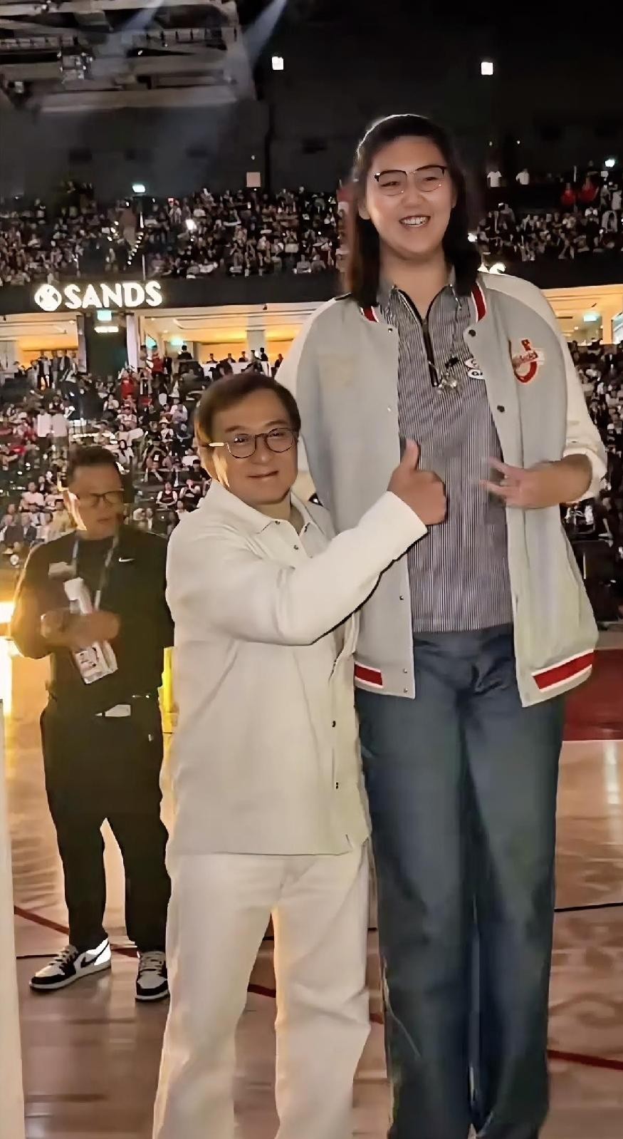 成龙大哥这辈子走南闯北什么大场面没见过，偏偏在女篮姑娘张子宇面前，硬生生被衬托成了“手办大小”。两个