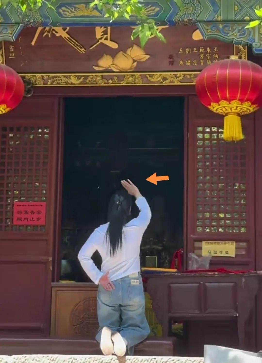 一穿白衣姑娘跪地拜佛手势舞动。