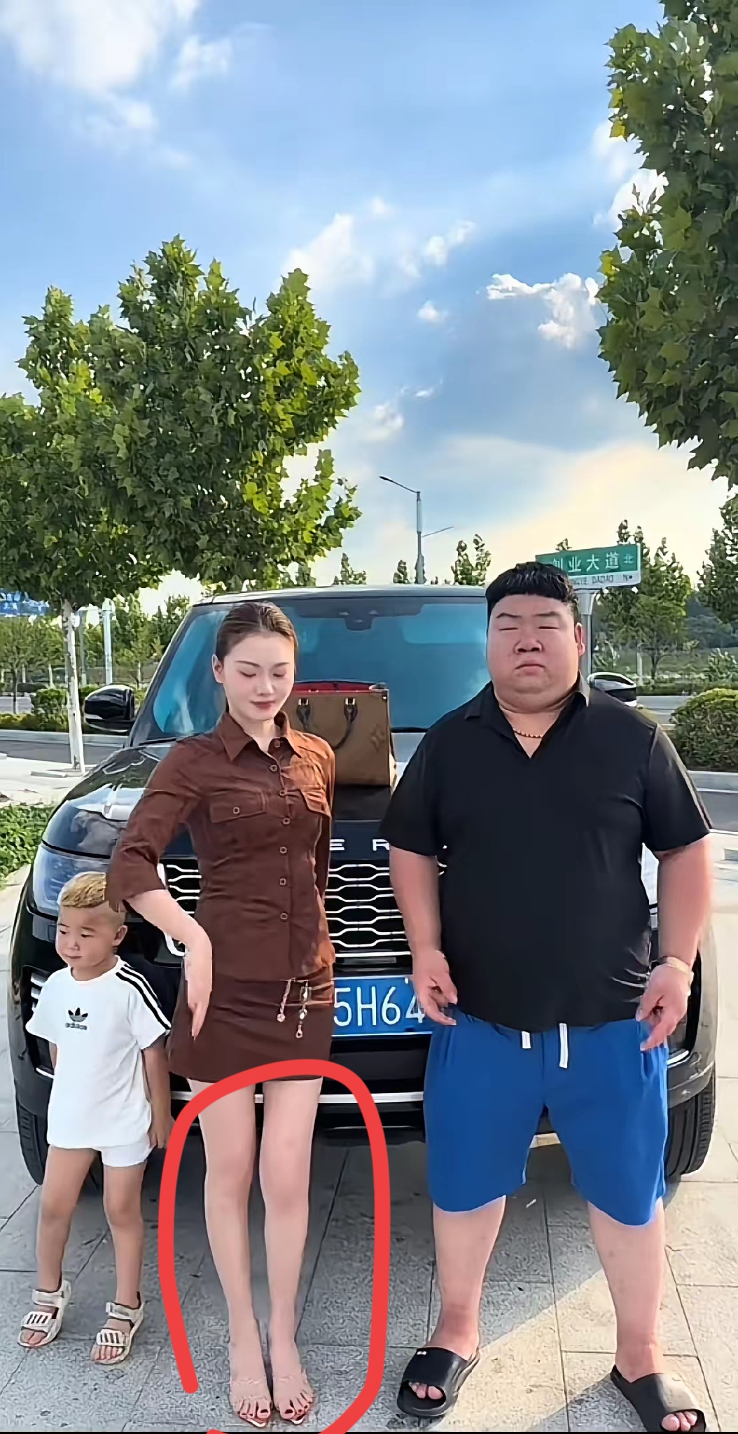 河南沁阳“李公子”街头全家炫富，让老婆穿着超短裙，露出大长腿，背着价值两万多的LV包包，和自己站在价