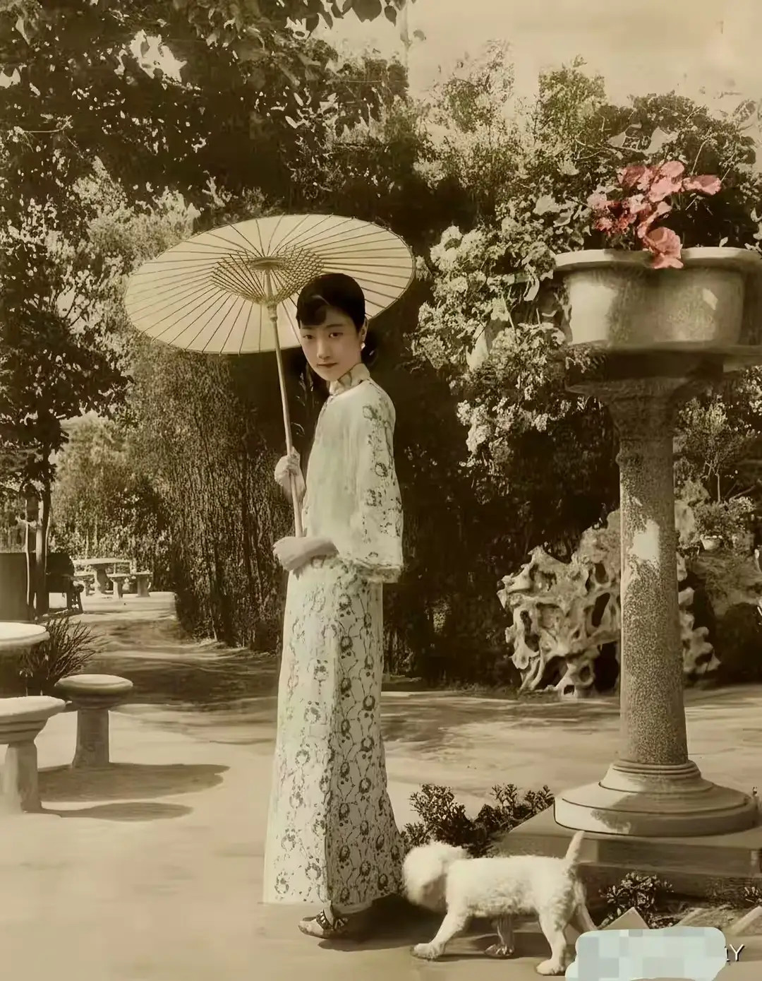 1928年天津张园，婉容撑伞在花园里遛狗时，一张珍贵留影