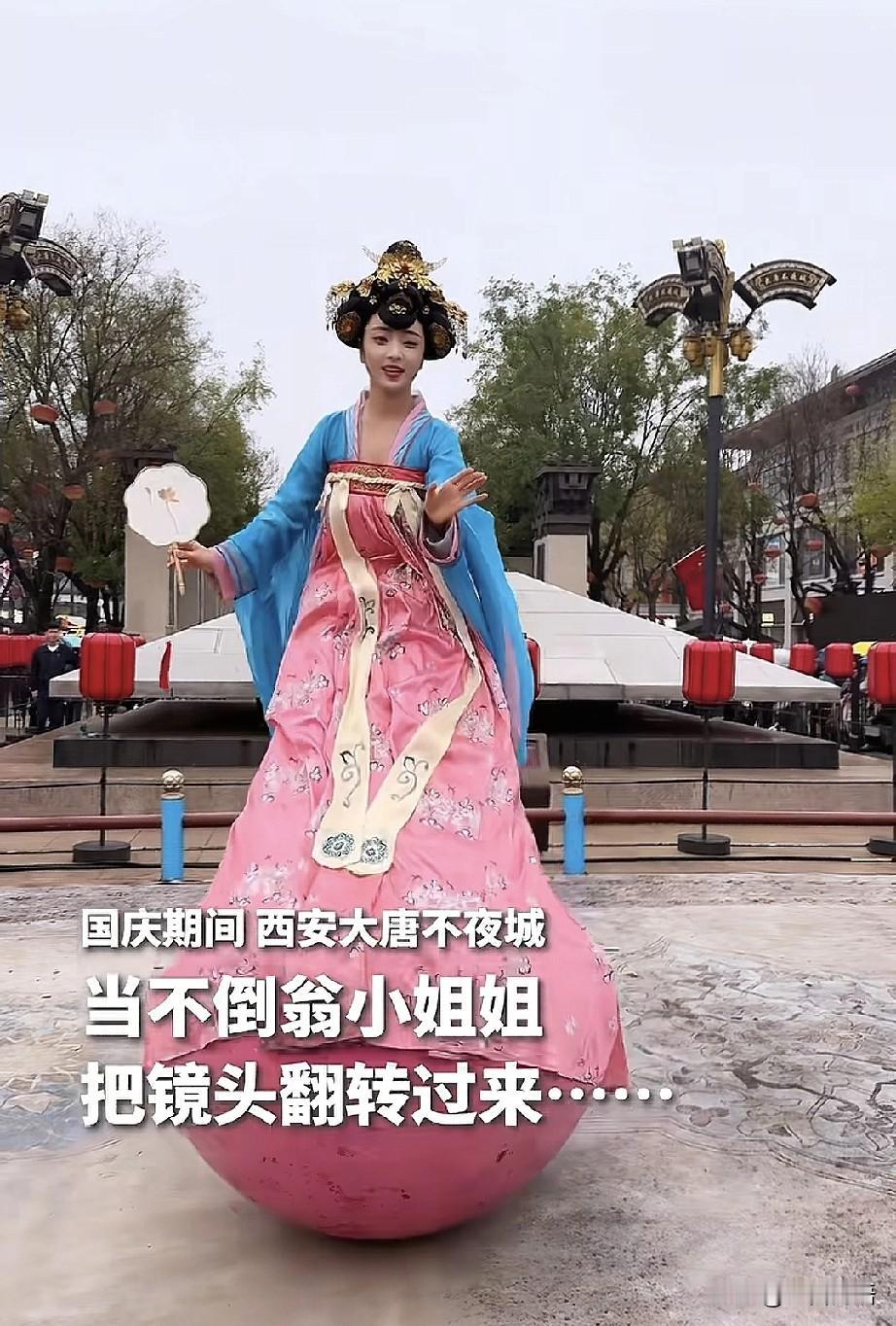 这一幕太暖了！前几天在西安大唐不夜城，一位游客的镜头原本对着“不倒翁小姐姐”，没