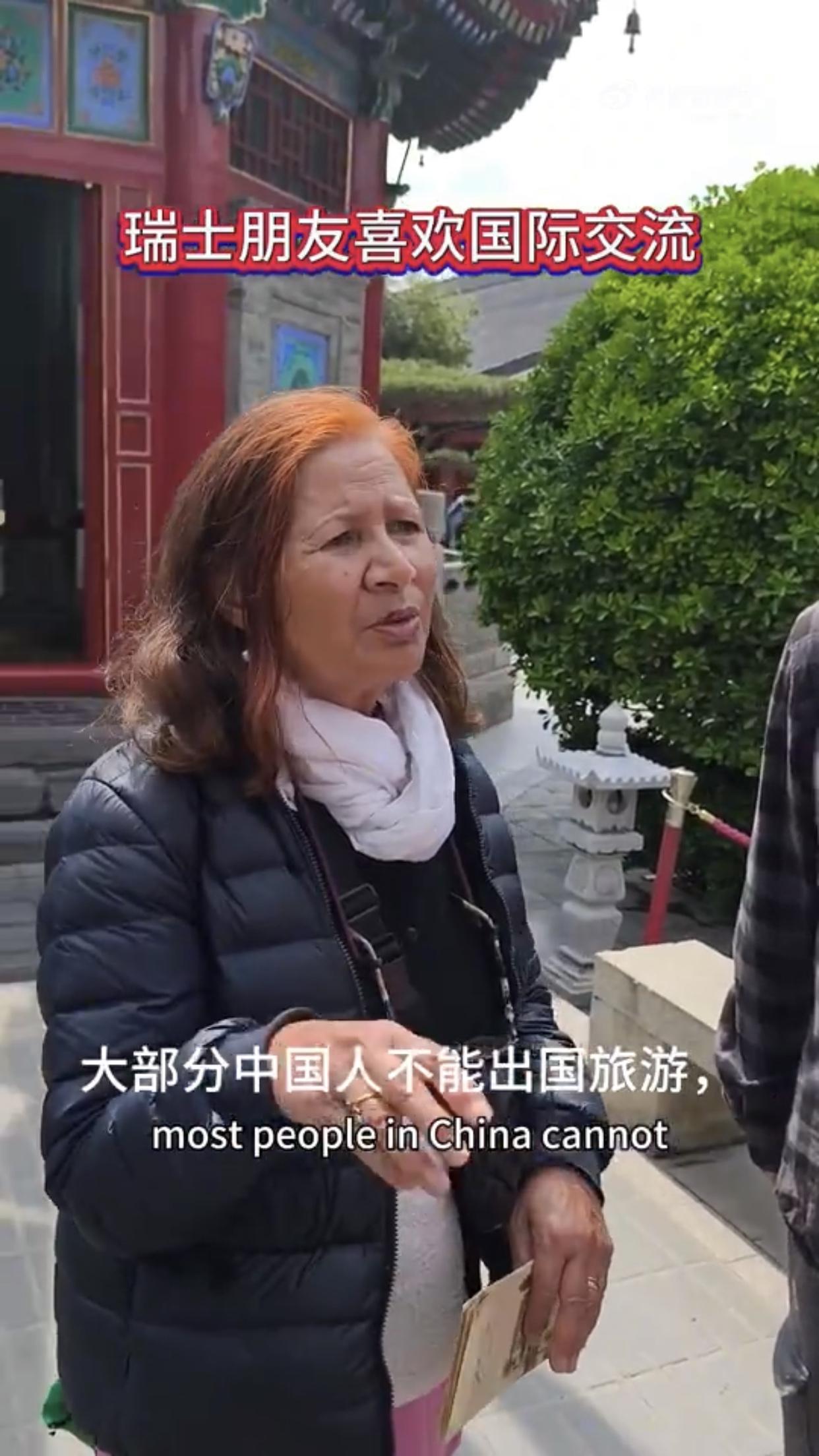 一对来中国旅游的瑞士游客对志愿者表示：大部分中国人不能出国旅游，因为他们没有足够
