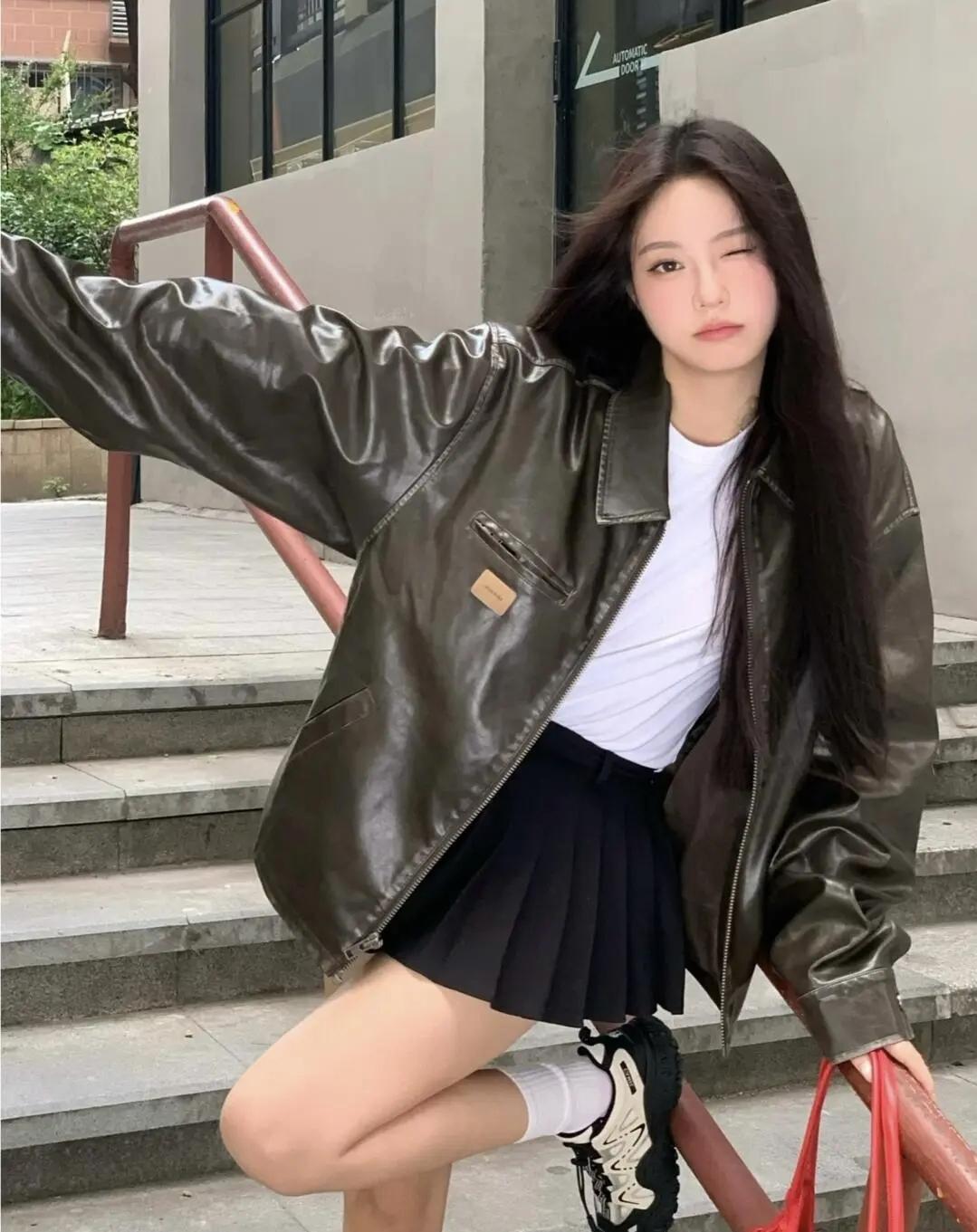 皮衣解锁街头酷感，红背包撞出点睛之笔，在城市街角定格随性的瞬间，风里都是自由的味