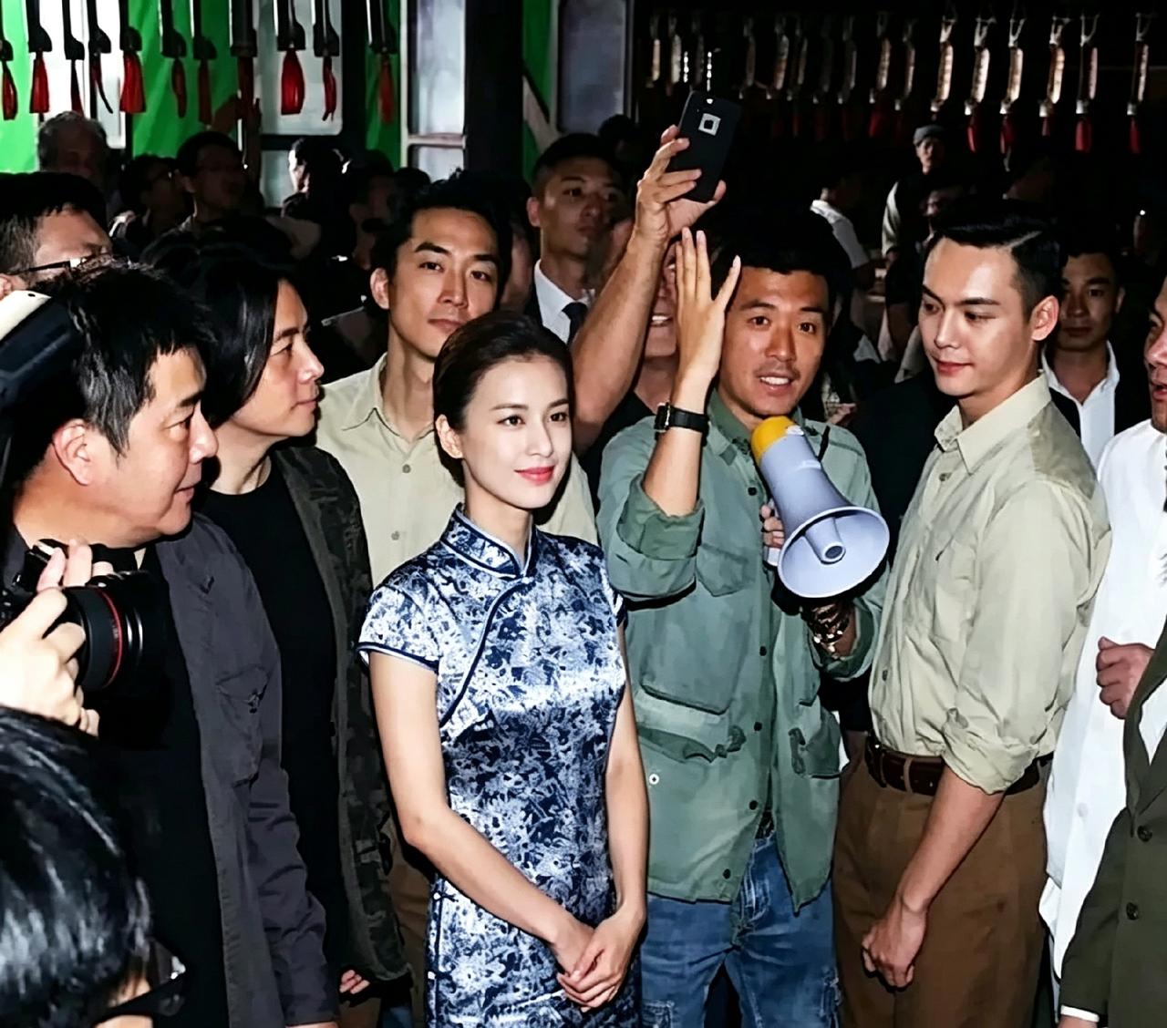 这张老照片出自《大轰炸》戛纳推介现场。黄圣依穿着旗袍站在人群中十分惹眼，杨子拿着