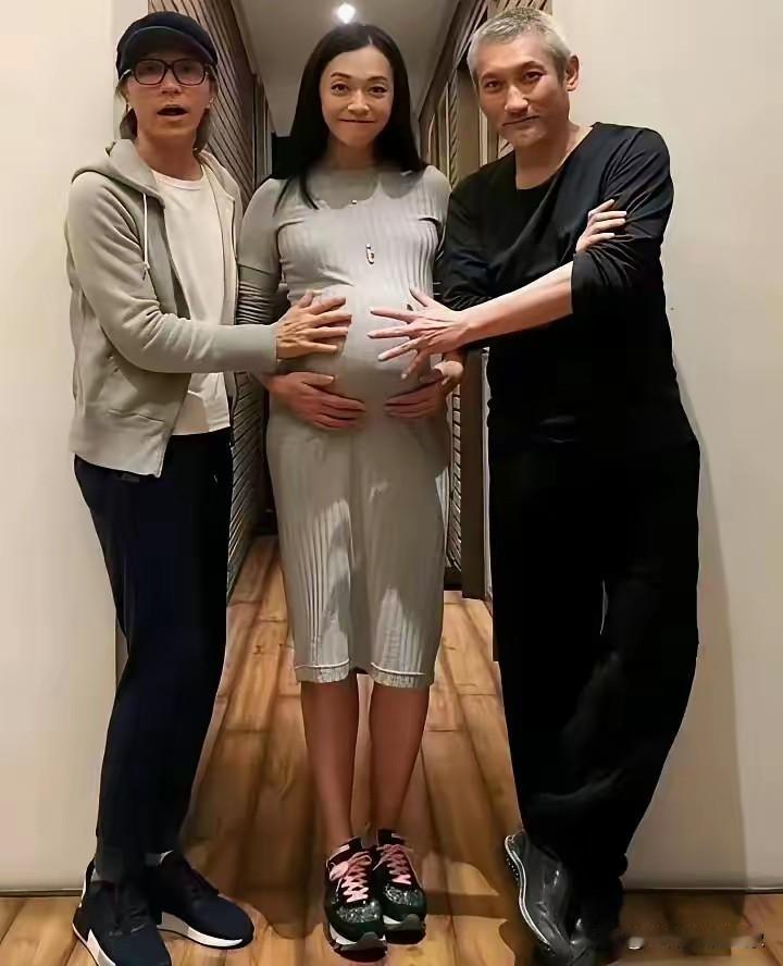 三人开心地围着孕妇的手。