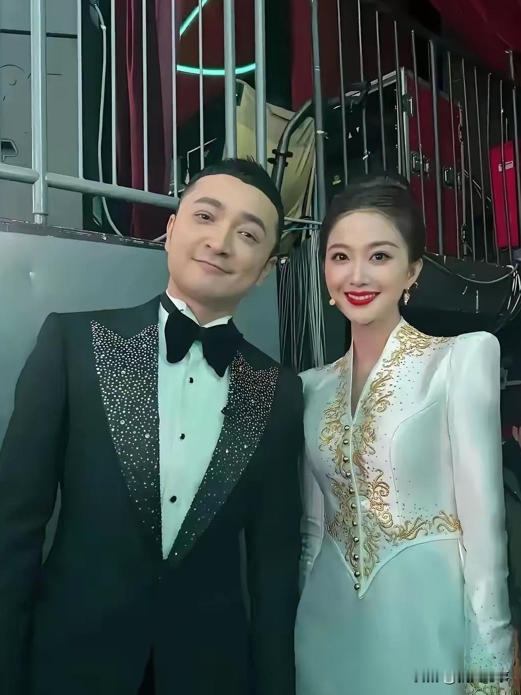 尼格买提身旁的她，一袭礼服温婉动人的春晚女主持。镜头下，尼格买提一身黑色亮纹西装