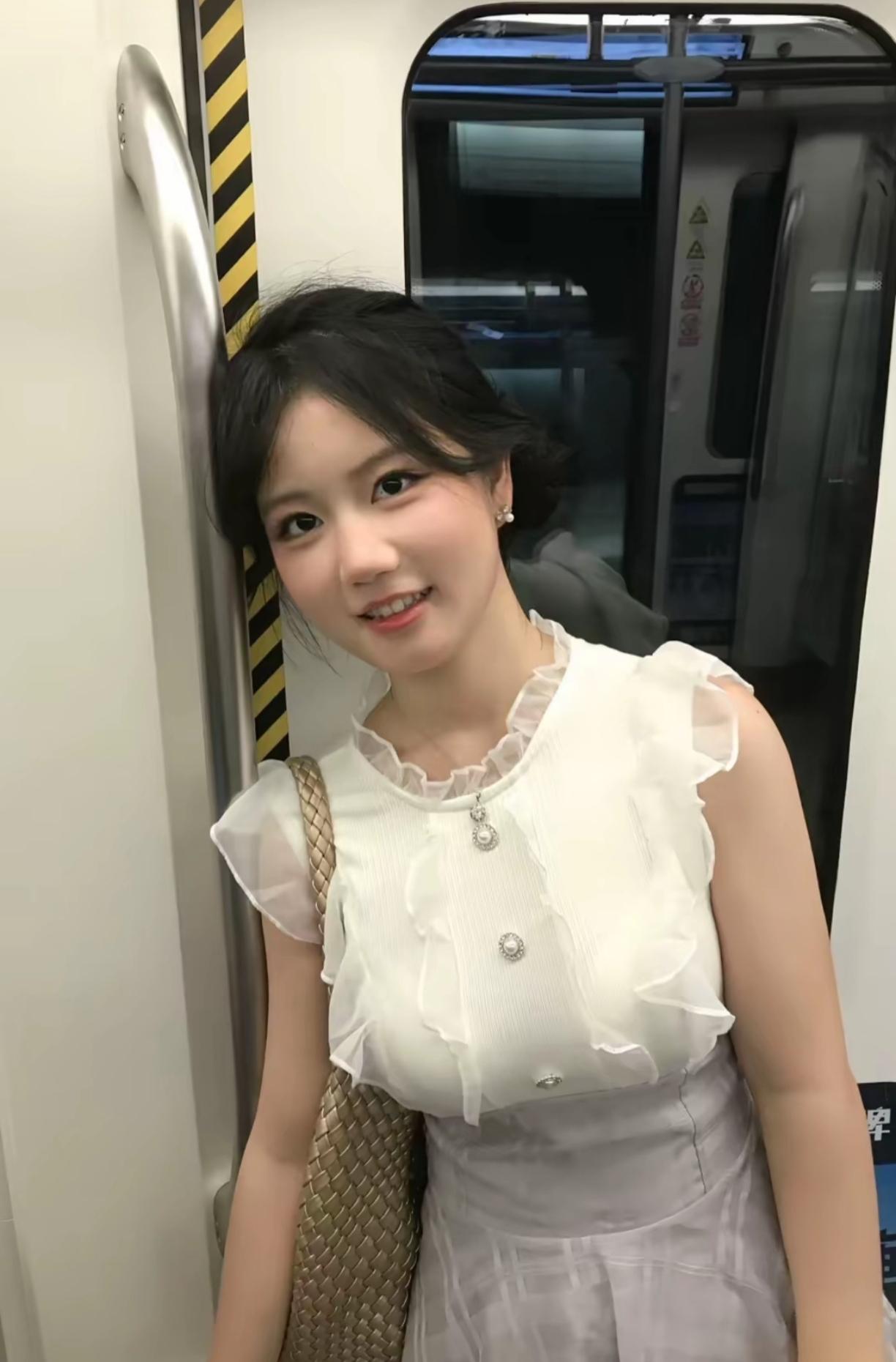 地铁上，一个漂亮的小姐姐靠在车门边。