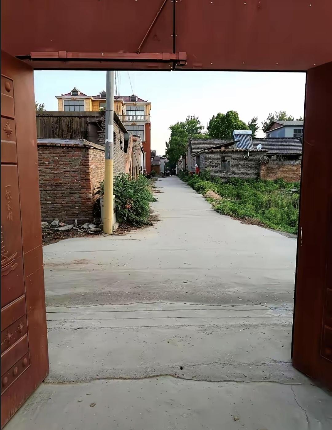 隔壁村老张头家盖房时非要把门冲着主路开。街坊说风水不好他当面骂封建迷信，现在他爸