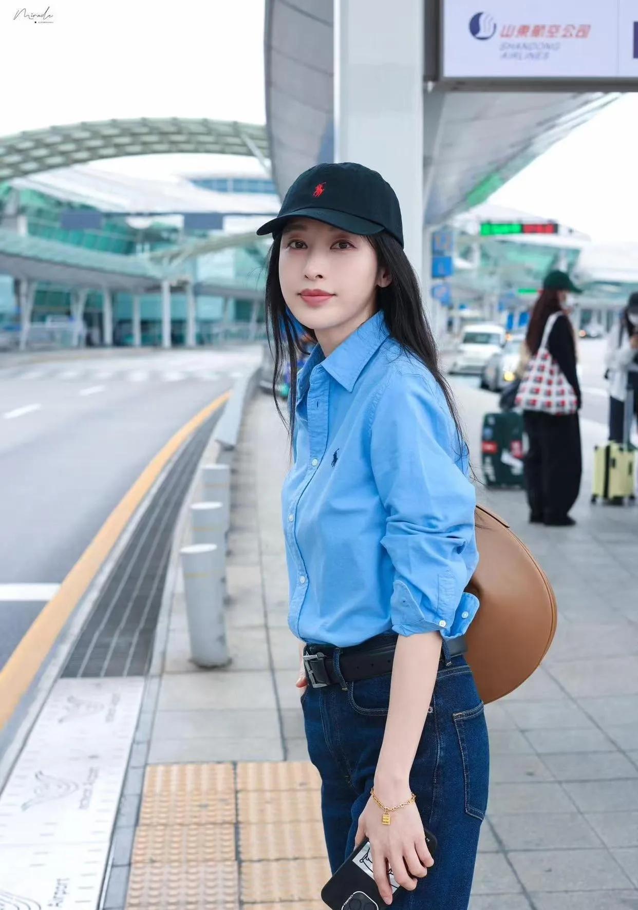 张俪的机场私服又赢麻了！一件清爽的蓝色衬衫+高腰牛仔裤，再配上一顶黑色棒球帽，整