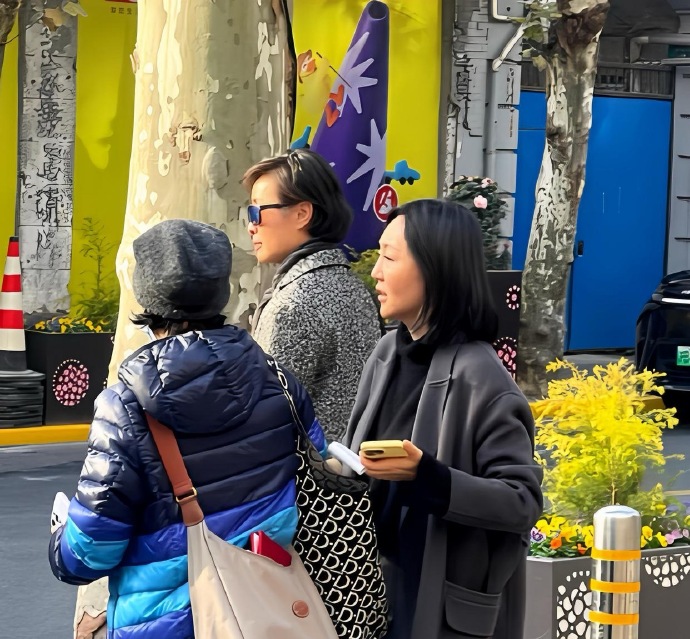 51岁的吴越与家人现身上海新天地，身着呢大衣，戴着墨镜，身姿高挑，气质超凡。她皮