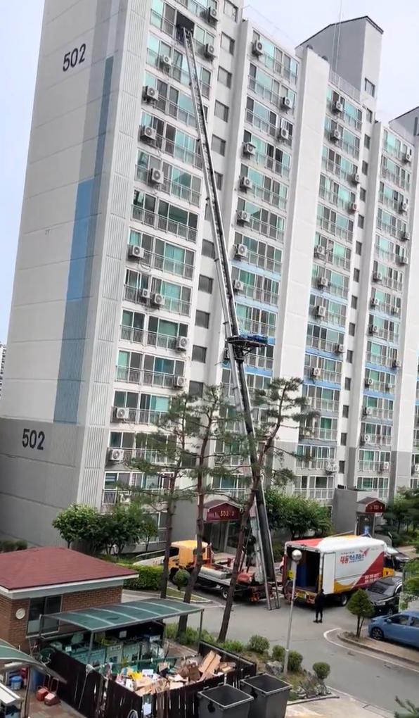 视频中一家韩国搬家公司使用一辆带有可伸缩臂的专用云梯车，直接将家具和箱子从高层公
