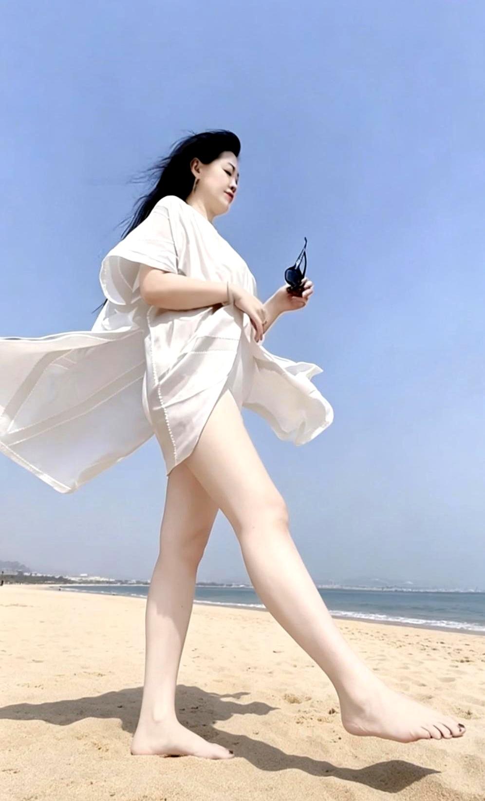 当正午海面被晒得像碎银时，天地之间亮得刺眼，城市人背着折叠椅往那条在短视频里反复