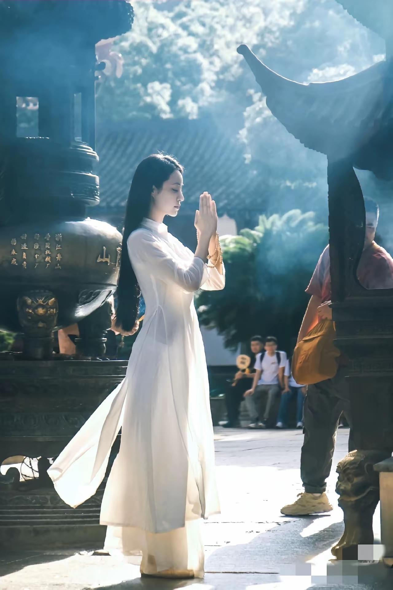 在古寺中，她一袭白衣，双手合十，静心祈祷。