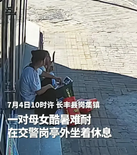 “看哭了！”安徽合肥，母女两人在等车，因天气太热只好在附近的交警岗亭外坐着休息，