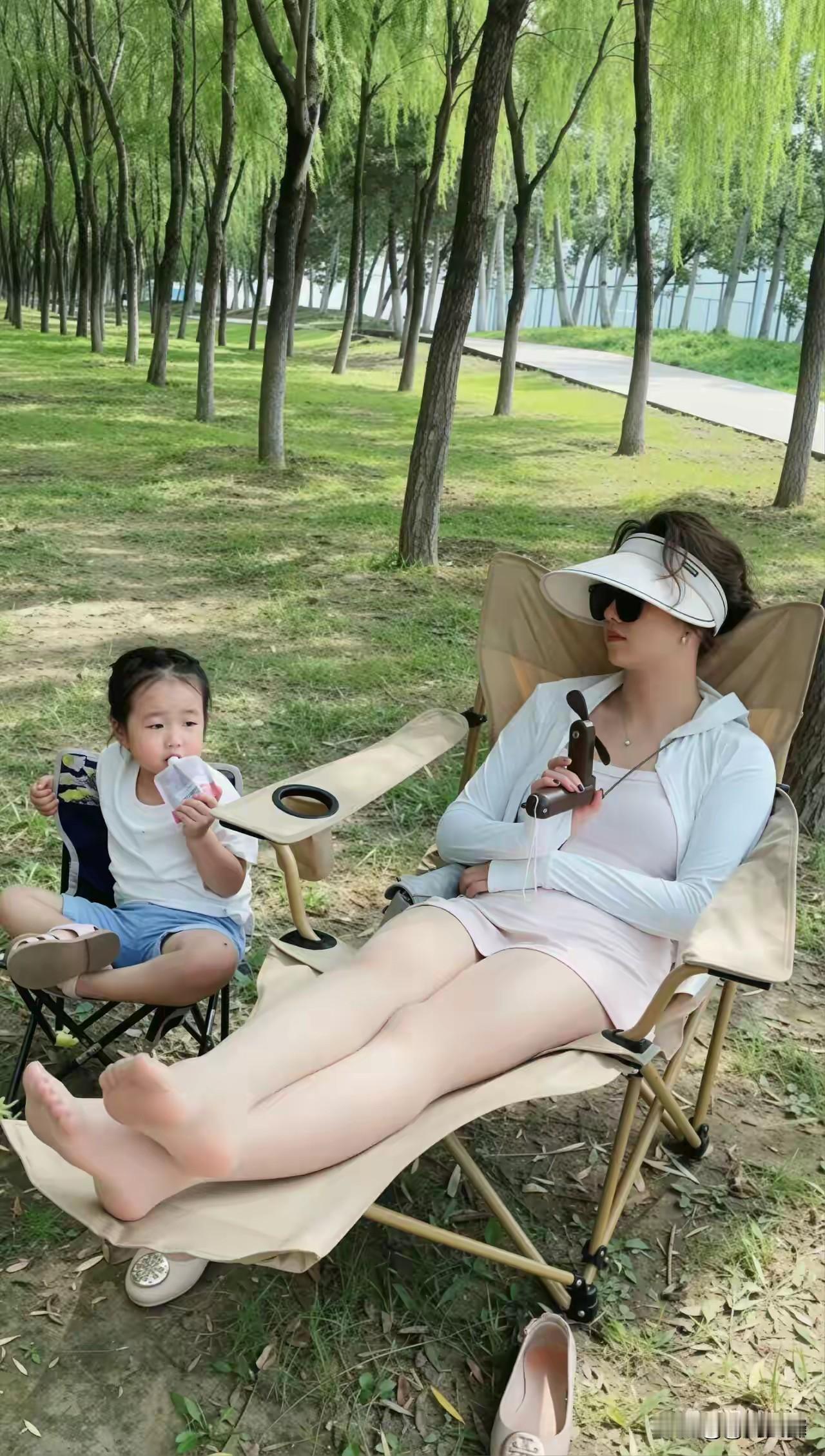 阳光下的悠闲时光，母女俩在树荫下享受野餐的美好。